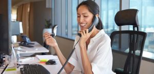 Woman sitting in the office and talking on the phone