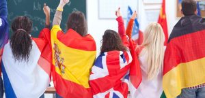 Five people with their backs to us and holding their country's flag